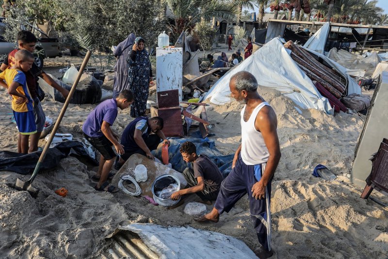 Palestinians inspect wreckage following Israeli strikes.